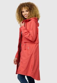 Abrigo impermeable rojo con capucha, que presenta una cintura ajustada, cierre frontal de cremallera, dos bolsillos laterales y una textura suave.