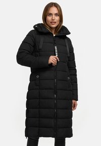 Le manteau d'hiver noir est doté d'une fermeture éclair à l'avant, d'une capuche et d'accents élastiques. Il présente un design matelassé avec une coupe mi-longue et des poches latérales.