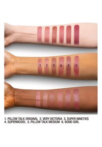 Sechs Lippenstiftfarben in Pink- und Mauvetönen auf drei Armen mit hellem, mittlerem und dunklem Hautton aufgetragen, beschriftet mit Farbnamen und Nummern.