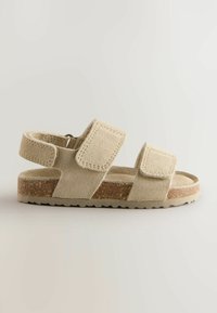 Beige Wildledersandaletten mit zwei verstellbaren Klettverschlüssen, einer strukturierten Sohle und einem flachen Design, ausgestattet mit einer strapazierfähigen korkähnlichen Zwischensohle.