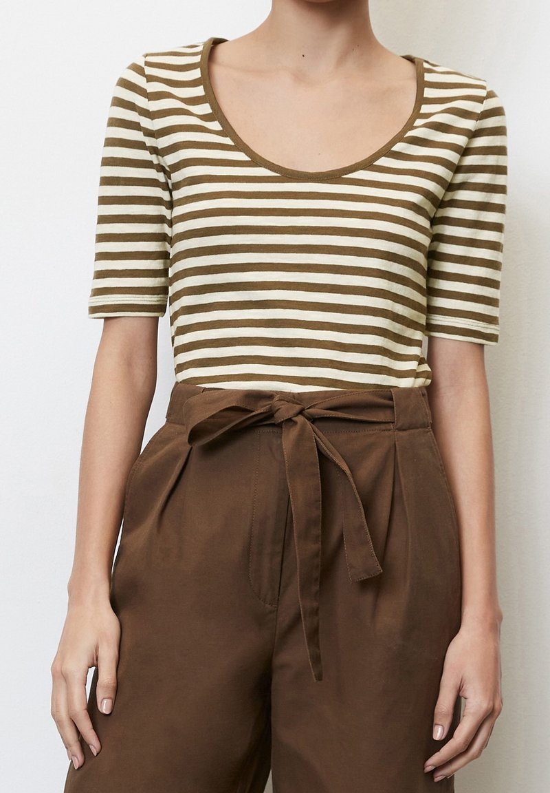 Pruhované hnědé a krémové tričko s krátkým rukávem a kulatým výstřihem, spárované s hnědými kalhotami s vysokým pasem a detailem vázačky v pase.