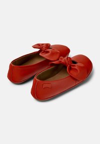 Bailarinas de cuero rojo con detalle de lazo anudado en la parte delantera, puntera redondeada y un sutil logotipo en el tacón.