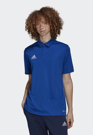 Polo bleu avec un col, manches courtes et patte de boutonnage à trois boutons. Présente le logo Adidas blanc sur la poitrine gauche. Texture de tissu lisse.