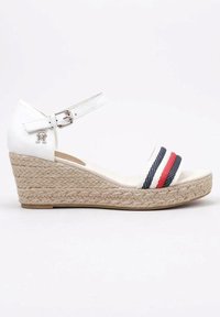 Sandalo con tacco a cuneo bianco con suola in stile espadrille, dotato di una fascia larga con strisce rosse e blu e cinturino alla caviglia regolabile. Include un accento del logo argentato.