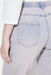Jeans in denim chiaro con una vestibilità leggermente rilassata, dotati di una tasca posteriore, sfumature sottili e una vita cucita.