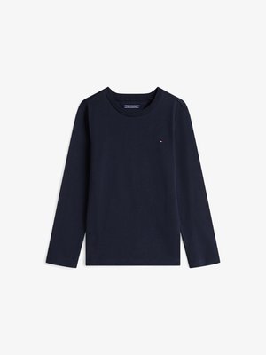 Tums zilas garām piedurknēm T-krekliņš, izgatavots no kokvilnas. Tam ir apļa izgriezums un neliels logotipa elements uz krūšu daļas. Gluda tekstūra un standarta piegriezums.