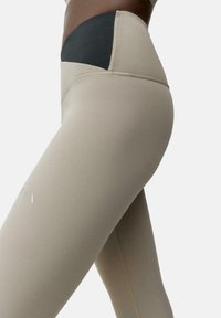 Beez leggings kõrge musta vöökohtaga. Üksikasjalik, sile tekstuur kontrastse musta paneeliga; sisaldab peegeldavaid logo detaile.
