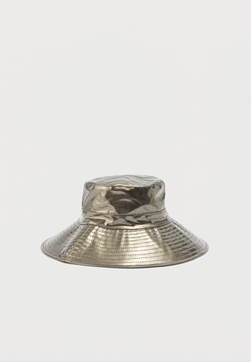 Ασημένιο μεταλλικό καπέλο τύπου bucket με φαρδύ γείσο, ραφές και ελαφρώς ζαρωμένη υφή σε απλό φόντο.