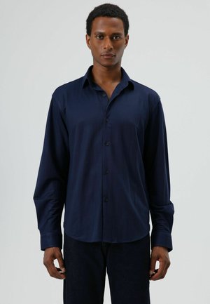 Navyblauw overhemd met knopen, gemaakt van gladde stof, voorzien van een klassieke kraag, lange mouwen en een afgeronde zoom. Simpel ontwerp zonder patronen.