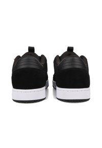 Czarne sneakersy z zamszową cholewką, zaokrąglonym kształtem, białą podeszwą pośrednią i fakturowanymi tylnymi panelami. Wyposażone w pętelkę, co ułatwia zakładanie.