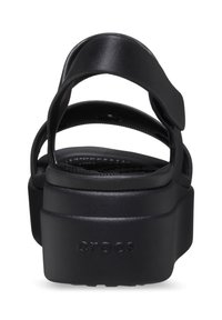 Schwarze Plateausandalen mit mehreren Riemen, aus strapazierfähigem Material gefertigt. Verfügen über eine strukturiierte Sohle und dezente Markenkennzeichnung an der Ferse.