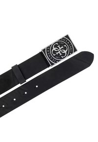 Cinturón de cuero negro con una hebilla rectangular de plata que presenta un diseño de logo circular, incluyendo texto y adornos. Textura suave.