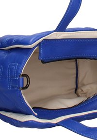 Sac à main en cuir bleu avec doublure intérieure blanche, fermeture éclair sur le dessus ouverte et poignée rembourrée visible.