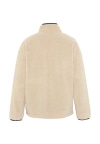 Beige, fluffy fleece jacket with a high collar and long sleeves. Features a black accent at the cuffs and a straight, relaxed fit.
