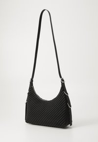Μαύρη υφασμάτινη τσάντα χειρός με καμπυλωτό σχήμα, υφασμάτινη υφή, λεπτό λουράκι, μεταλλικές λεπτομέρειες και φερμουάρ στο επάνω μέρος.