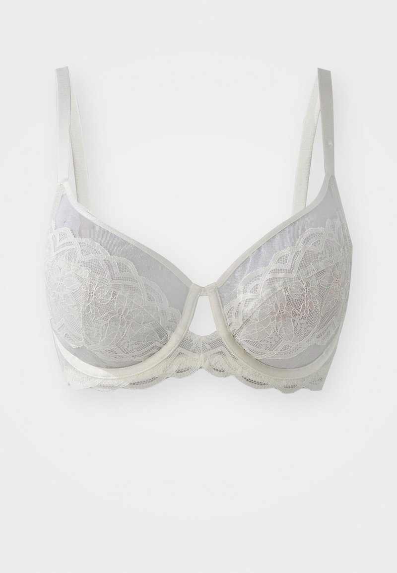 Šviesiai į tōrąs spalvos nėriniuotas liemenukas su permatomomis taurėmis, banguotais kraštais ir reguliuojamomis petnešėlėmis. Puikuojasi gėlių nėrinių raštu ir minkštu apačiu.