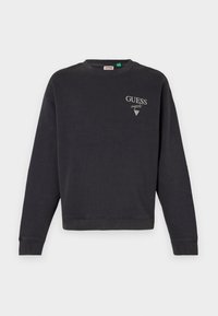 Mörkgrå sweatshirt med rund halsringning, ribbade ärmslut och nederkant. Har "GUESS original"-logotyp i vitt på framsidan, tillverkad av mjukt tyg.