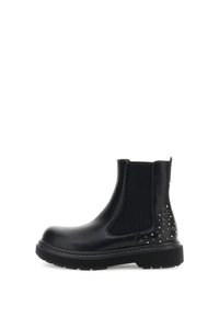 Botas negras de tobillo con paneles laterales elásticos y tachuelas decorativas de metal en el talón. Suela de goma texturizada y parte superior de sintético suave.