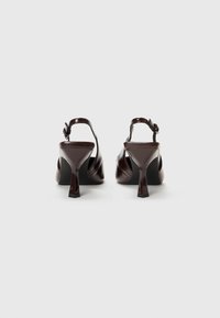 Ruske patentleather slingback-korkokengät, joissa on neliön muotoinen kärki ja lohkopohja. Sisältää solmuhimmeen nilkkaremmissä. Suuri pinta.