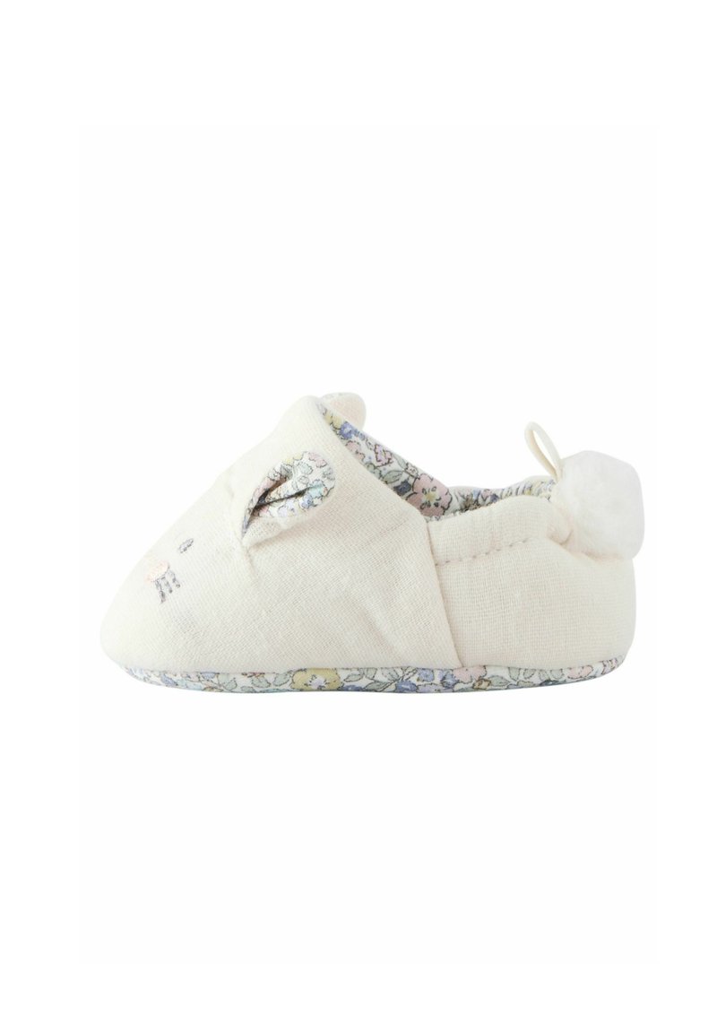 Zapatilla de color beige claro con forma redondeada, que presenta orejas de conejo, un forro con un estampado floral y un pompon esponjoso en el talón.