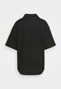 Camicia nera a maniche corte con vestibilità rilassata, dotata di colletto, orlo dritto e texture liscia. Design semplice senza ulteriori decorazioni.