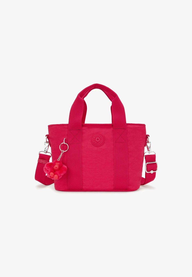 Red fabric tote bag with short handles and a detachable adjustable strap. Features a logo patch and a pink monkey-shaped charm.
