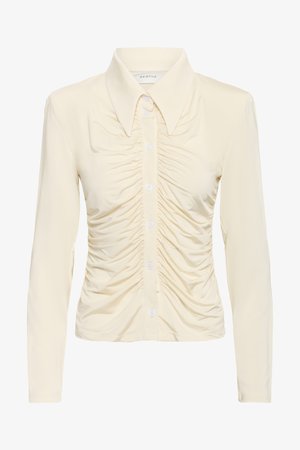 Kreemivärvi pikkade varrukatega pluus, mille ees on nööbid, bodi piirkonnas on voltidega detail ning klassikalise kraega disain.