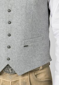Gray felt waistcoat with five metallic buttons, a chest pocket, and a silver hardware accent, paired with beige trousers.
