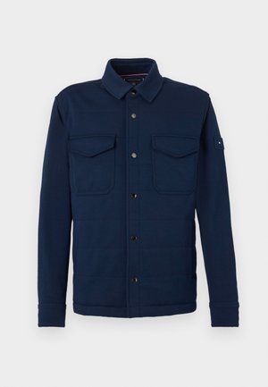 Tengerészkék zakó gombos elülső résszel, két mellzsebbel és tartós gallérral. Puha, texturált anyagból készült, finom varrási részletekkel.