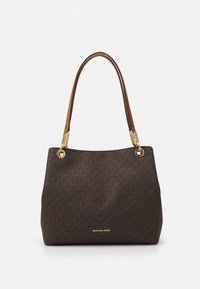 Smeđa torba od tkanine s zlatnim metalnim detaljima, ukrašena logotipom i uzorkom. Ima dvostruke smeđe kožne naramenice u jednostavnom, strukturiranom obliku.