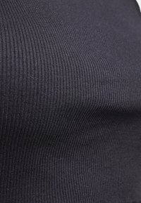 Black ribbed fabric close-up, featuring fine vertical lines and a smooth texture. The material has a slight sheen and elasticity.