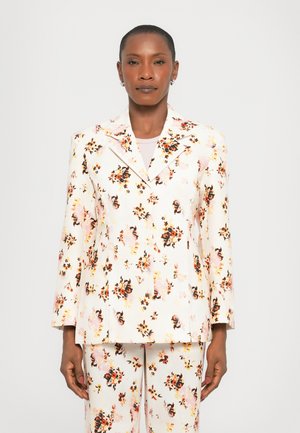 Conjunto de traje floral con un fondo crema y flores vibrantes en naranja y negro. La chaqueta tiene un cuello con muescas y está entallada.