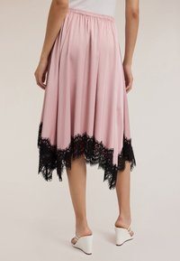 Gonna midi rosa chiaro con un design fluido, caratterizzata da un dettaglio in pizzo nero lungo l'orlo. Vita elastica e tessuto lucido e morbido.