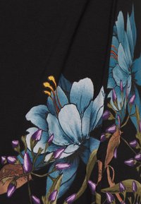 Czarny materiał z kwiatowym wzorem, zawierający duże niebieskie kwiaty, fioletowe pąki i zielone liście. Gładka tekstura o żywych kolorach.