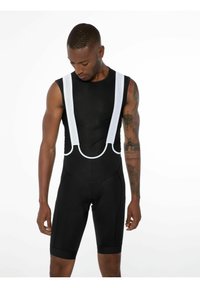 Schwarze Radsport-Bib-Shorts mit weißen Mesh-Trägern, taillierte Passform und dehnbarem Stoff. Mit gepolstertem Sitzbereich für zusätzlichen Komfort.