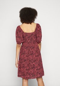 Rotes Blumenkleid mit gepufften Ärmeln, quadratischem Rücken, gerafftem Oberteil und knielangem Rock, verziert mit einem Rosendessin.