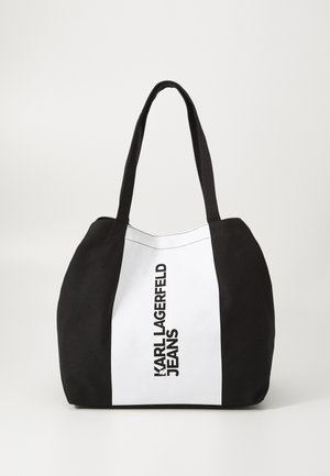 Black and white canvas tote bag with long handles, featuring "KARL LAGERFELD JEANS" printed vertically in bold black text on the white panel.