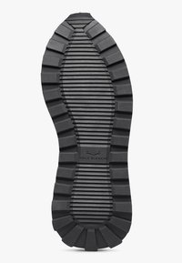 Suola di sneaker in gomma nera con un motivo scanalato, con un logo centrale che recita "VOILE BLANCHE" e un design testurizzato e resistente.