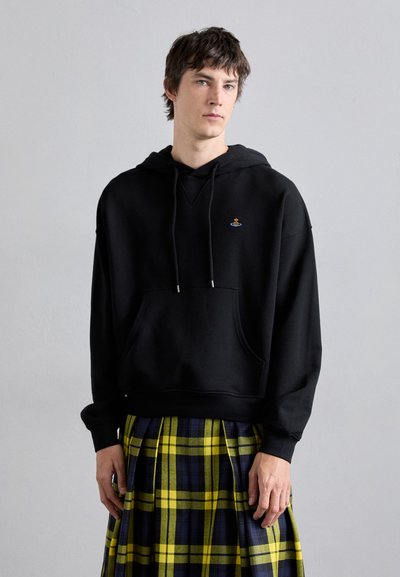 Zwarte hoodie van een katoenmix, met een voorzak, een capuchon met trekkoord en een klein geborduurd logo. Gecombineerd met een geel-blauwe geruite rok.