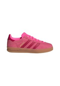 Baskets Adidas Gazelle roses avec dessus en daim, trois bandes rose foncé, semelle en gomme et fermeture à lacets sur fond blanc.