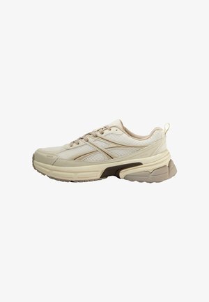 Beige sportieve schoenen met een bovenwerk van mesh, getextureerde accenten en een gevoerde zool. Bevat veters, logo details en een aantrekband op de hiel.
