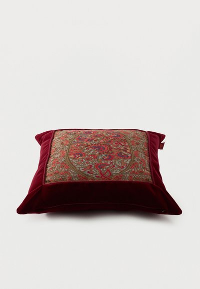 Coussin carré avec des bords en velours rouge profond et un panneau central présentant un motif floral et cachemire multicolore complexe.