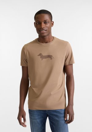 Camiseta de manga corta en tono claro, hecha de un tejido suave, con un gráfico de un dachshund marrón en la parte delantera. Cuello crew clásico y corte regular.