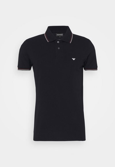 Svart polo-skjorte i bomull med krage. Har to knapper, korte ermer og flerfargede striper på kragen.