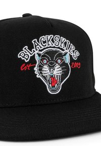 Černá baseballová kšiltovka s vyšitým designem černého pantera. Text "BLACKSKIES" v bílé barvě, červené detaily a "est. 2009" pod grafikou.