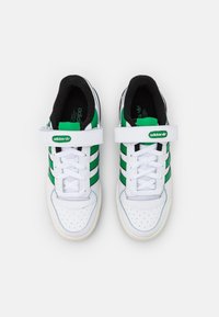 Vita sneakers med gröna ränder, lädermaterial, rund tå, kontrasterande svart foder och justerbart rem vid vristen.