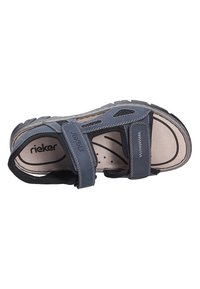 Blue hiking sandal with adjustable straps, open design, cushioned footbed, and durable rubber sole. Features logo detailing and ventilation holes.