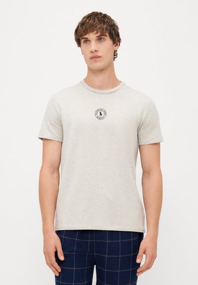 Lys grå t-shirt med korte ærmer lavet af blødt stof, med et lille rundt logo på brystet. Rund halsudskæring, almindelig pasform.