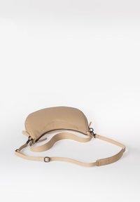 Beige lederen schoudertas met een gebogen vorm, ritssluiting en verstelbare schouderband. Soepele textuur met minimalistische ontwerpelementen.