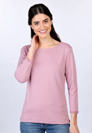 Langes, gestreiftes Oberteil in Pink und Weiß mit weitem Ausschnitt und gewellten Manschetten, aus weichem, dehnbarem Stoff. Getragen mit blauen Jeans.